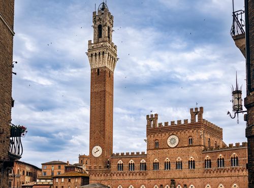 The iconic Torre del Mangia rising over Siena's Piazza del Campo in Tuscany, Italy.