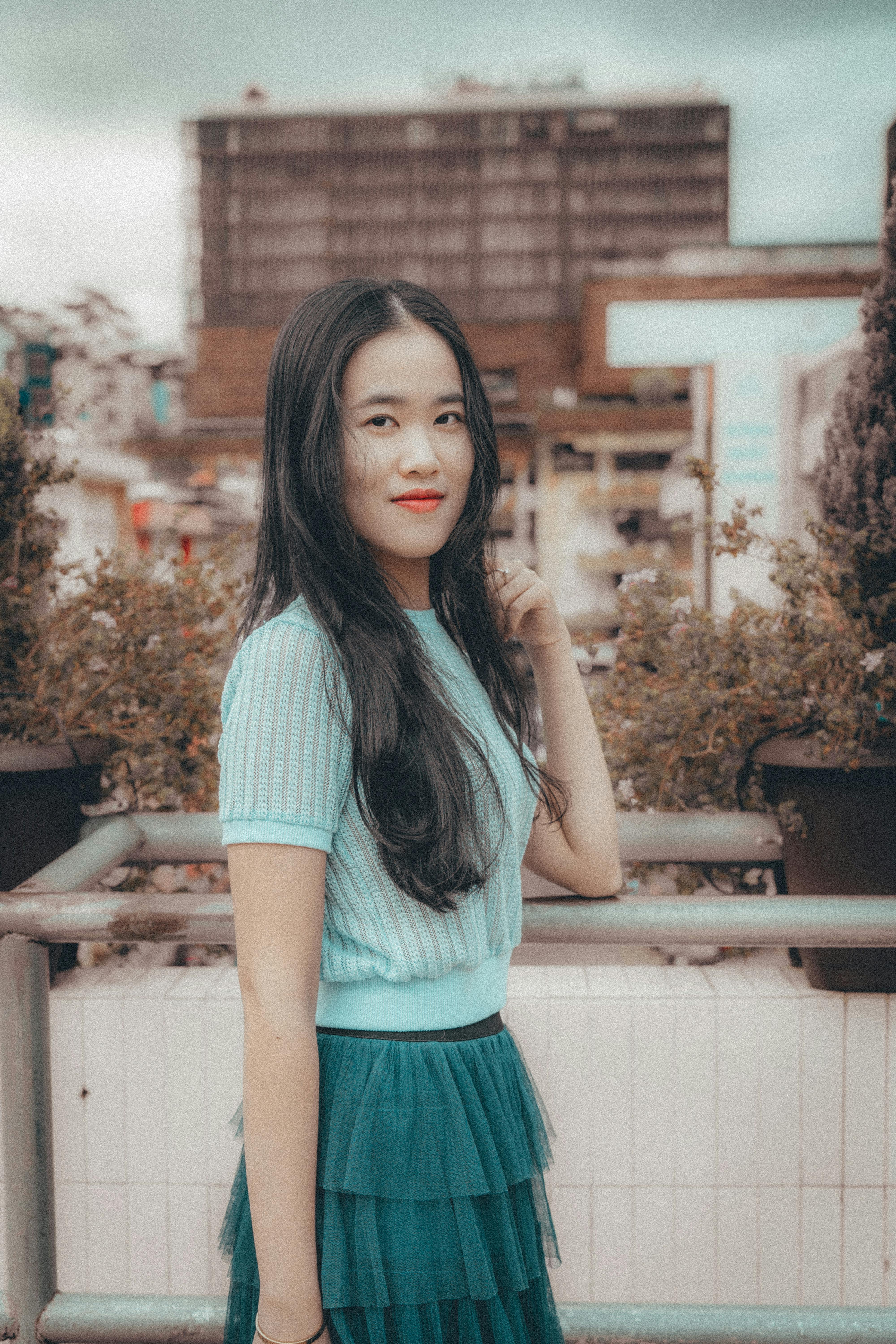 A stylish woman poses in urban Dalat, Vietnam, capturing vibrant city hues and fashion elements.