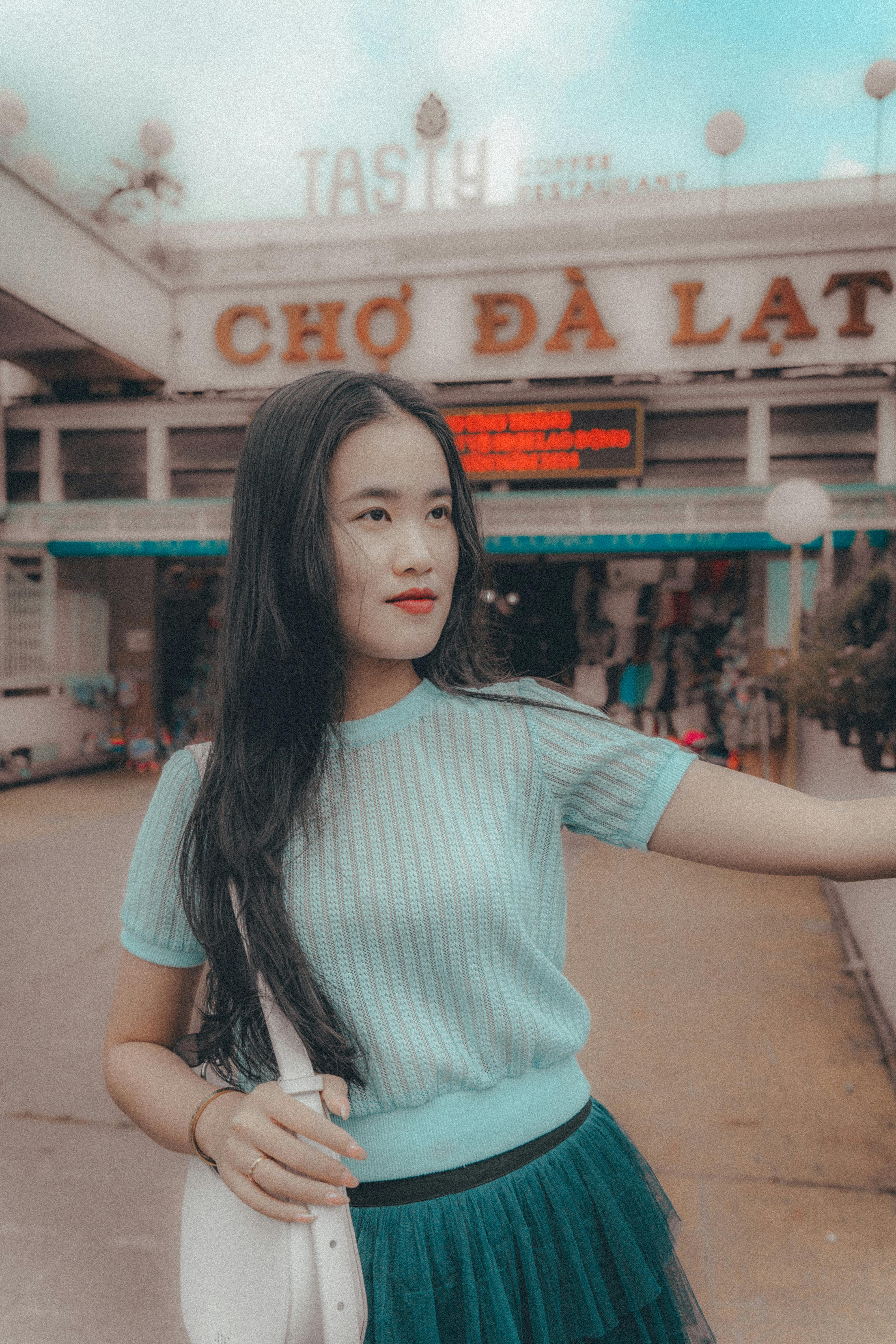 Asian woman in fashionable attire outside Dalat Market in Vietnam.