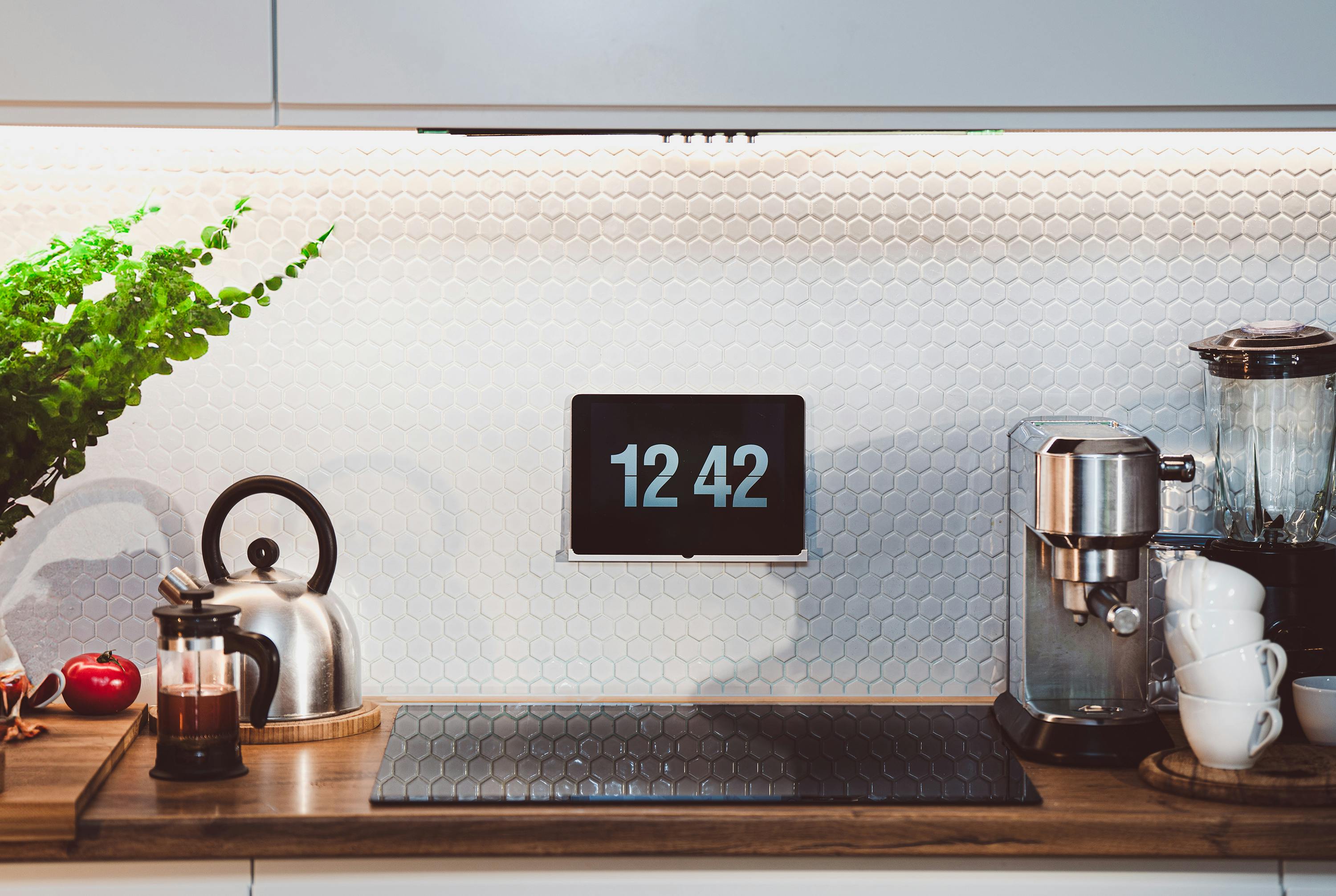 Stylish kitchen interior with digital clock and coffee machine on counter.
