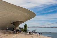 在清澈的蓝天映衬下，探索里斯本的现代建筑与风景优美的人行道