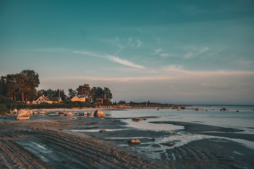 A beach with a house on it at sunset