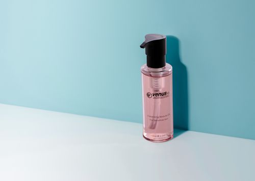 Free Pink cleansing oil bottle on a minimalist background, ideal for skincare and beauty themes. Stock Photo