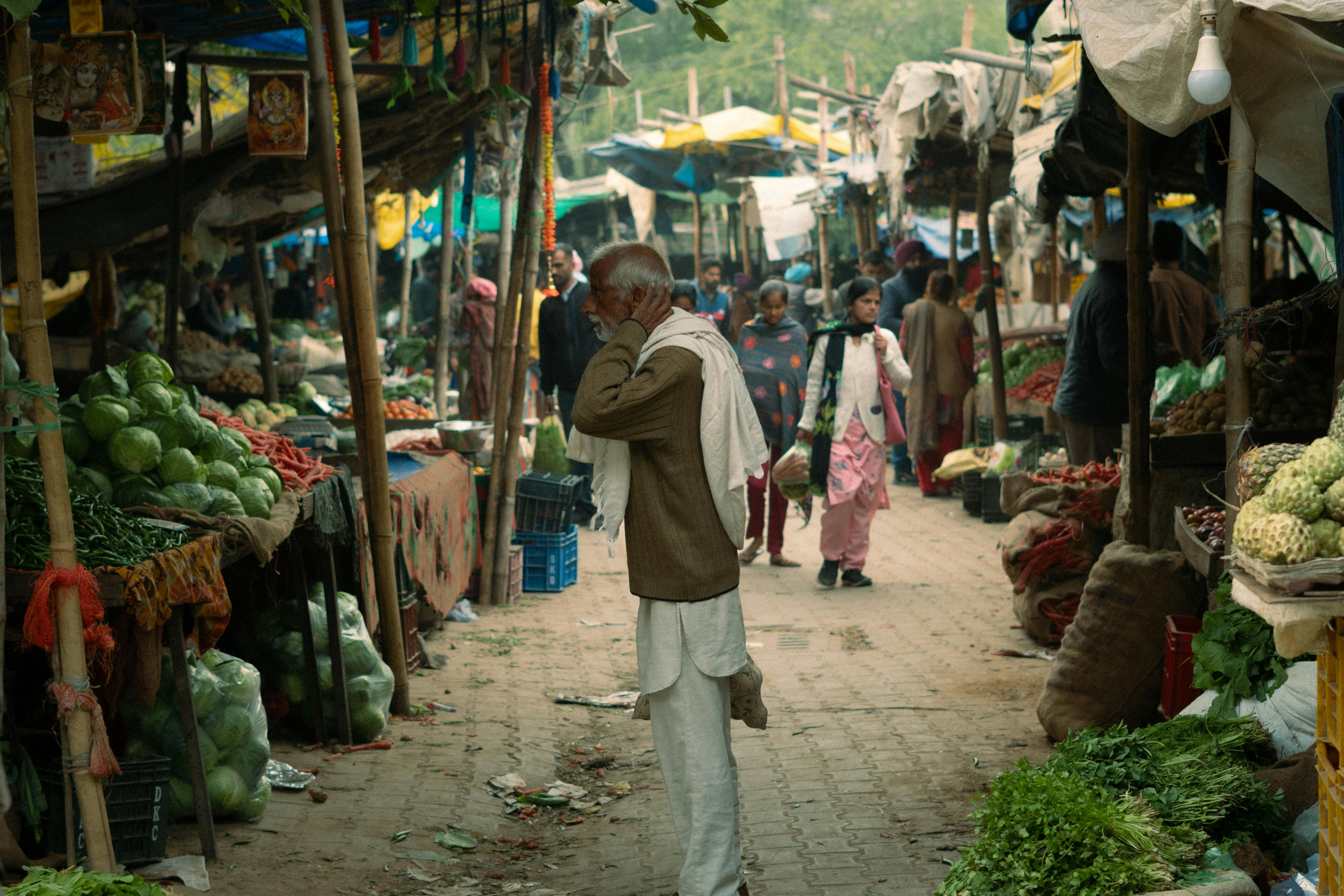 A man walking down a street with vegetables and fruits