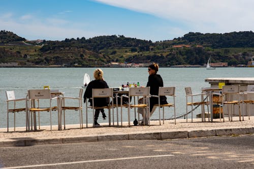 Deux Femmes Assises Sur Des Chaises Sous Le Ciel Bleu