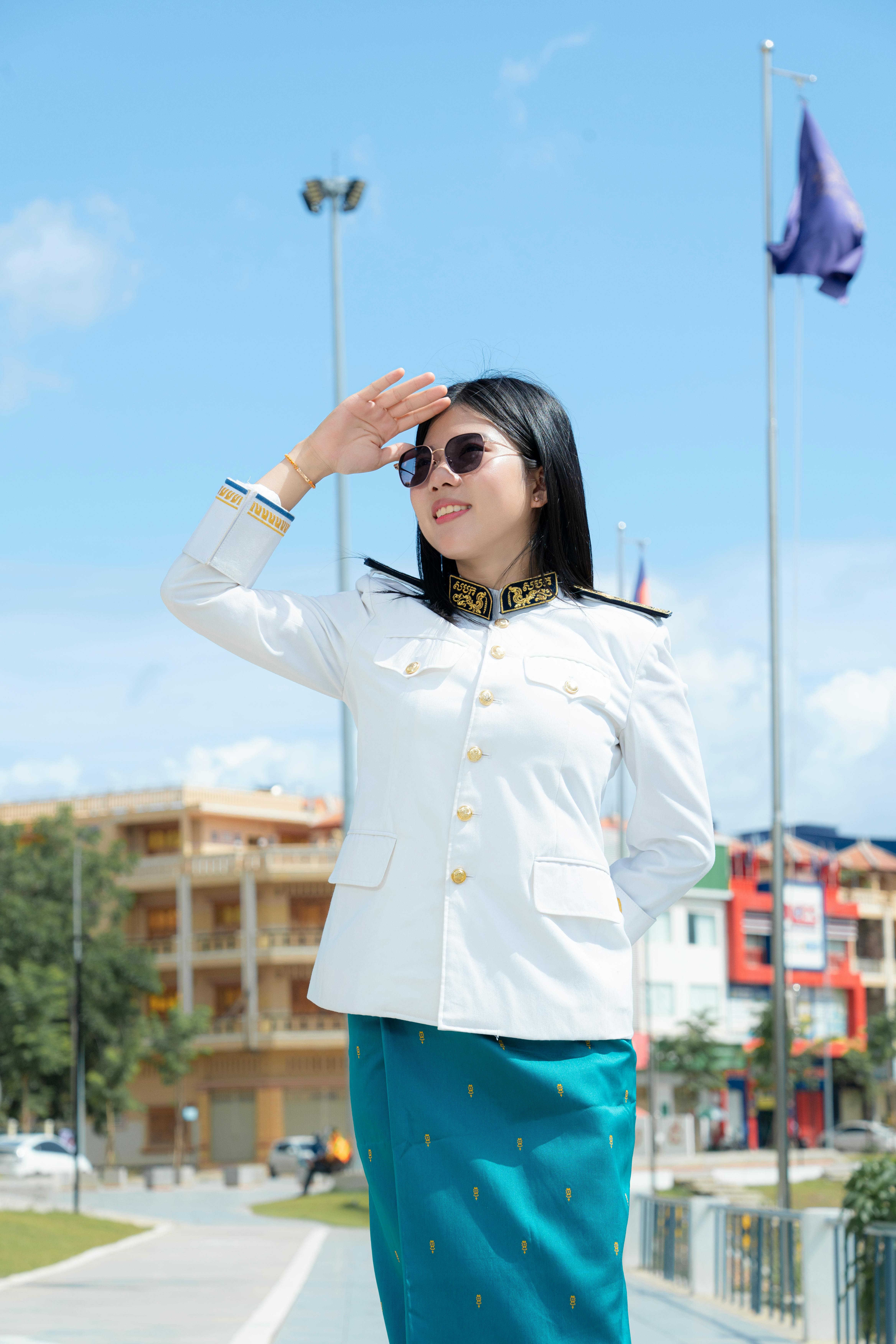 a woman in a white uniform saluting