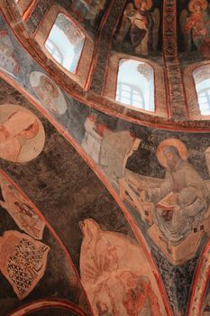 Detailed frescoes depicting religious scenes on an Orthodox church dome, showcasing artistic heritage