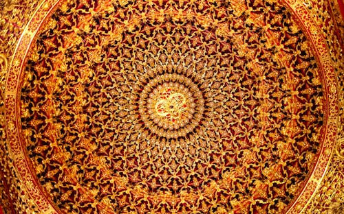 A circular ceiling with gold and red designs