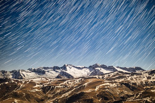 A long exposure photograph of snow covered mountains