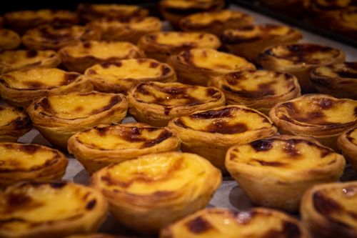 Free A close-up of freshly baked Pastel de Nata, iconic Portuguese custard tarts, in a Porto bakery. Stock Photo