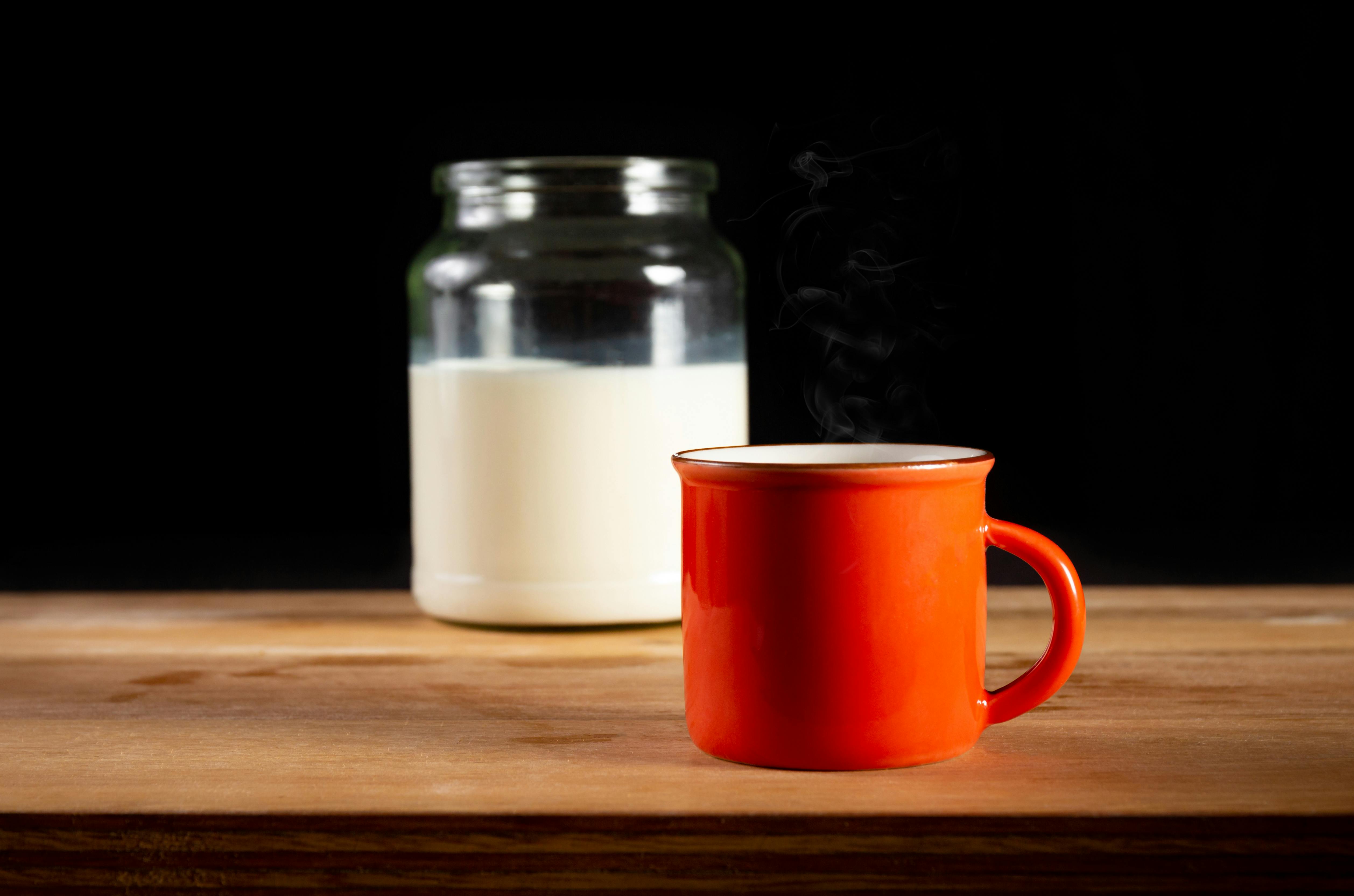 Warm Milk In A Cozy Setting With A Steaming Cup On A Bedside Table