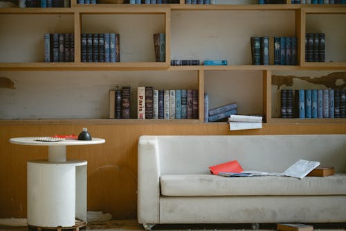 A white couch sits in front of a bookshelf