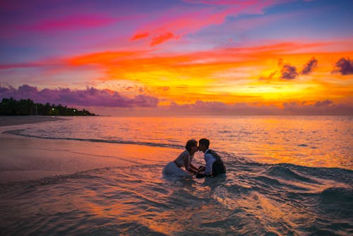 Hombre Y Mujer Besándose En El Océano Durante La Puesta De Sol