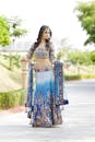 A beautiful indian woman in blue and gold lehenga