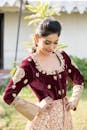 A woman in a maroon and gold anarkali suit