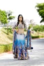A beautiful indian woman in blue and gold lehenga