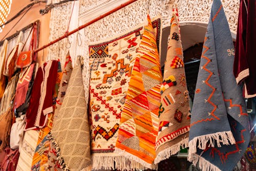 A variety of colorful rugs hanging on a wall