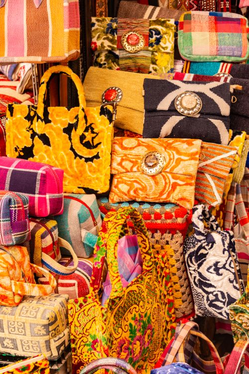 Free Vibrant collection of handmade handbags on display at a market, showcasing colorful patterns and textures. Stock Photo