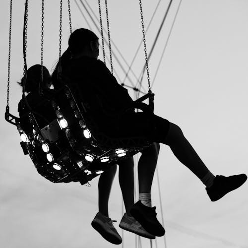 Two people on a swing at a carnival