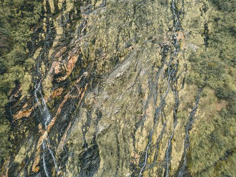 A stunning aerial view capturing the intricate waterfall patterns on a rocky hillside in Lwang Ghalel, Nepal.