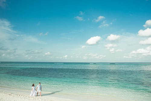 新娘和新郎站在沙灘線上