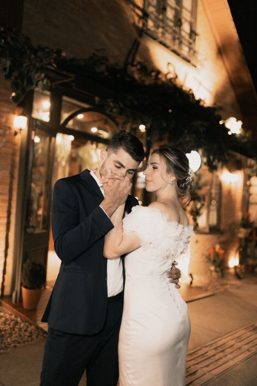 Free Intimate wedding moment of a bride and groom in a romantic nighttime setting with ambient lights. Stock Photo