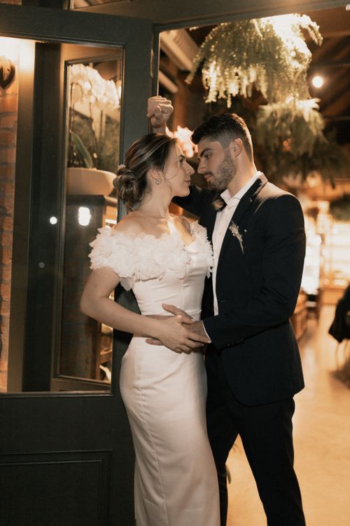 Free A bride and bridegroom sharing a loving moment indoors in elegant wedding attire. Stock Photo