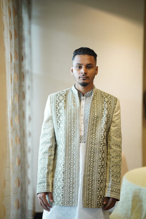 A man in an indian style jacket and pants