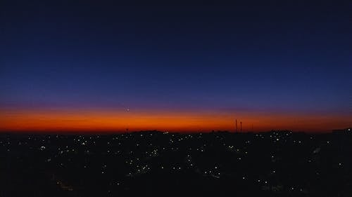 夜のオレンジ色の空の下の街