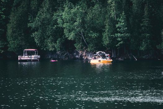 Boats along the serene lake at Mont-Tremblant, surrounded by lush forest.