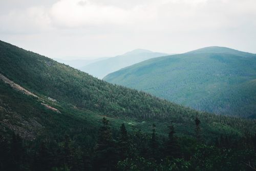 Free Lush green mountain range under cloudy sky in Gaspé, Canada during summer. Stock Photo