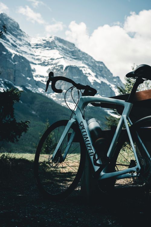 Free Bicycle resting against a bench with stunning view of mountains in Banff, Canada. Stock Photo