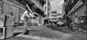 一张孩子们在斋浦尔街道上打板球的单色照片，捕捉了城市生活