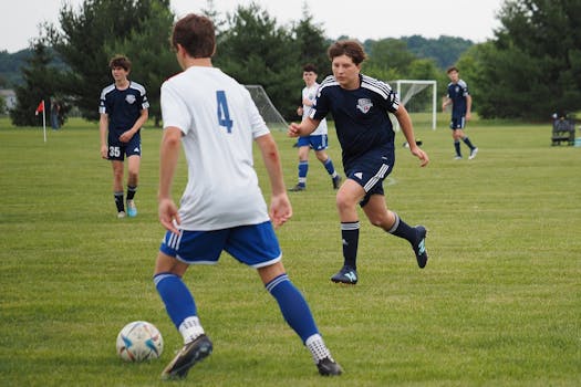 Teen boys playing soccer on a grassy field in Warrington, PA.