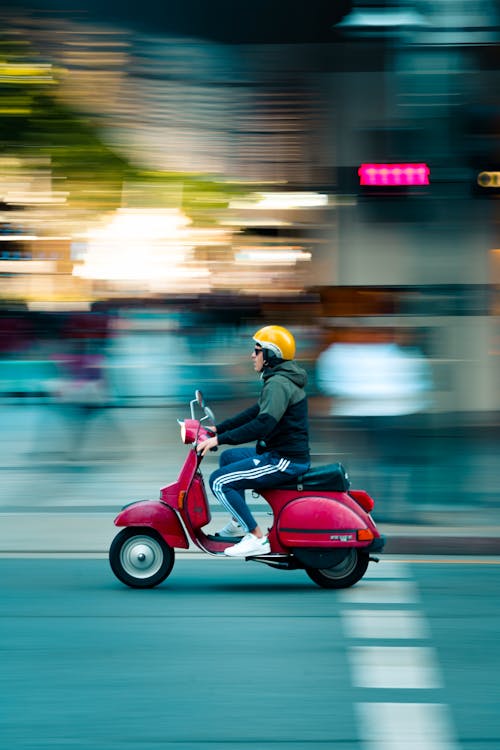 빨간 모터 스쿠터를 타는 남자의 사진