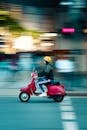 Photo of Man Riding Red Motor Scooter