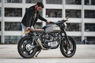 在埃因霍温，一名男子站在一辆定制的本田咖啡馆赛车摩托车旁