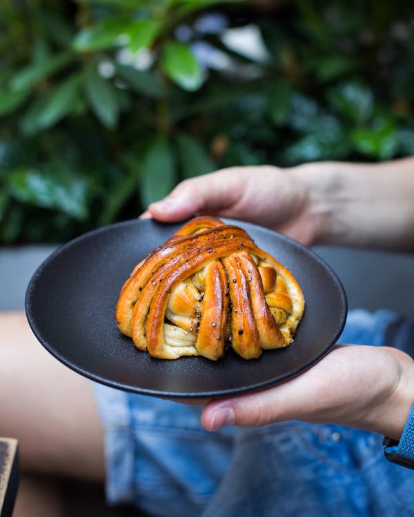 Person Holding A Plate of Bread