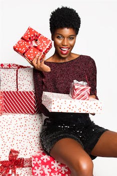 一位快乐的非裔美国妇女拿着圣诞礼物，兴奋地表达着节日的欢乐