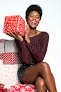 一位面带微笑的非裔美国妇女在白色背景上高兴地拿着圣诞礼物
