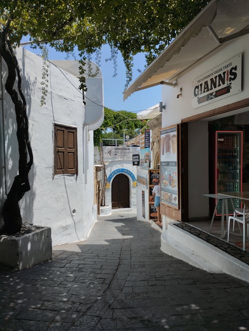 A narrow street with shops and tables