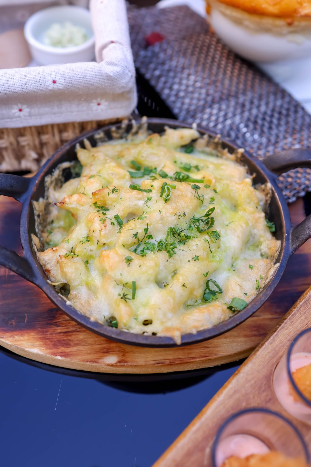 baked mac and cheese recipe topped with melted cheese and herbs