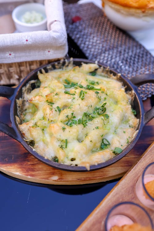 Free Delicious homemade baked macaroni and cheese topped with melted cheese and herbs, ideal for comfort food lovers. Stock Photo