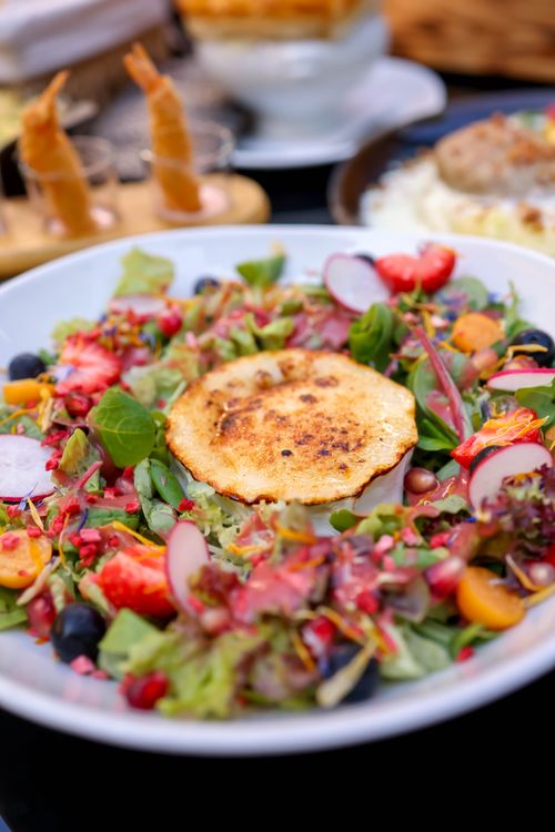 Free Vibrant salad with fresh ingredients and goat cheese in a close-up view, perfect for food photography. Stock Photo