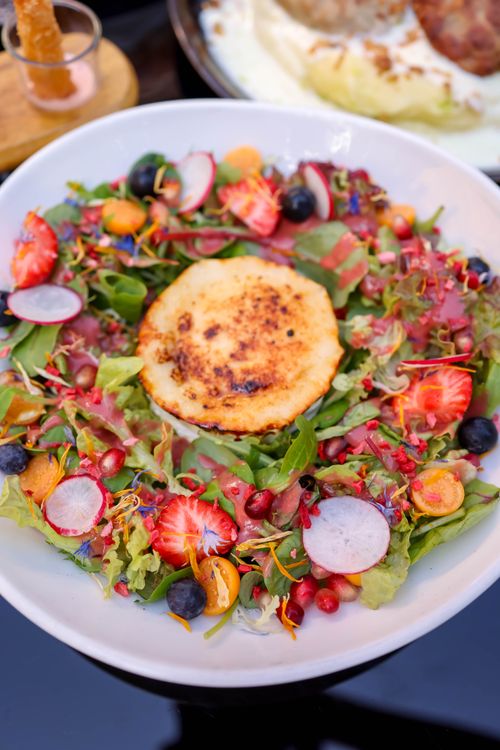 Free Delicious fresh salad with grilled cheese, berries, and radishes. Perfect for a healthy summer meal. Stock Photo