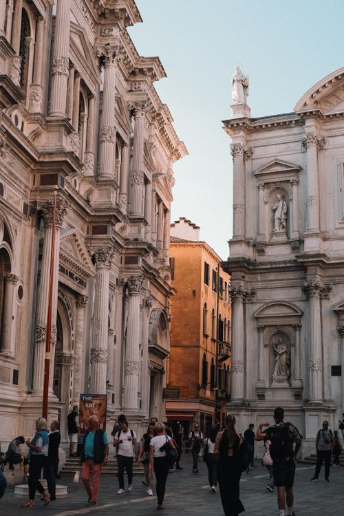 Free Tourists exploring ornate Baroque churches in Venice's historic center. Stock Photo