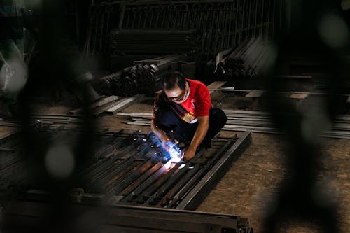 Welder Squatting and Working