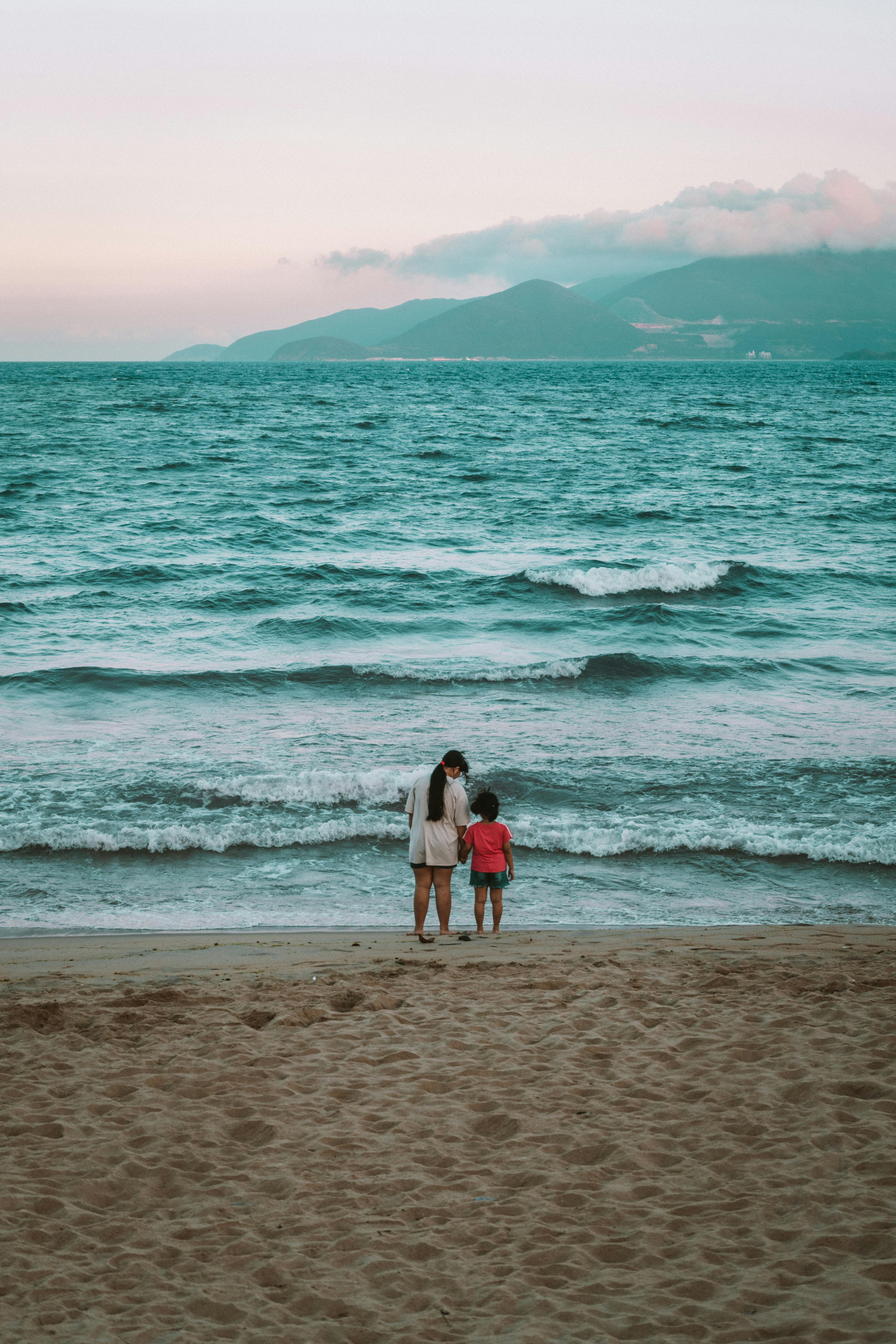 woman and child standing on seashore