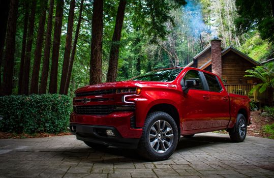 A side-by-side comparison of a base work truck and a high-end model highlighting various Chevy Silverado engine options.