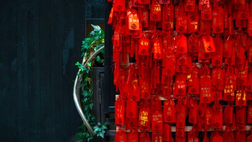 Free Red prayer cards hanging on a wall in a Buddhist temple, symbolizing wishes and beliefs. Stock Photo
